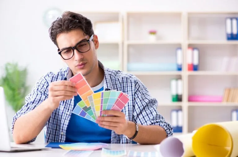 A focused man actively engaged in the design process, selecting colors for a room