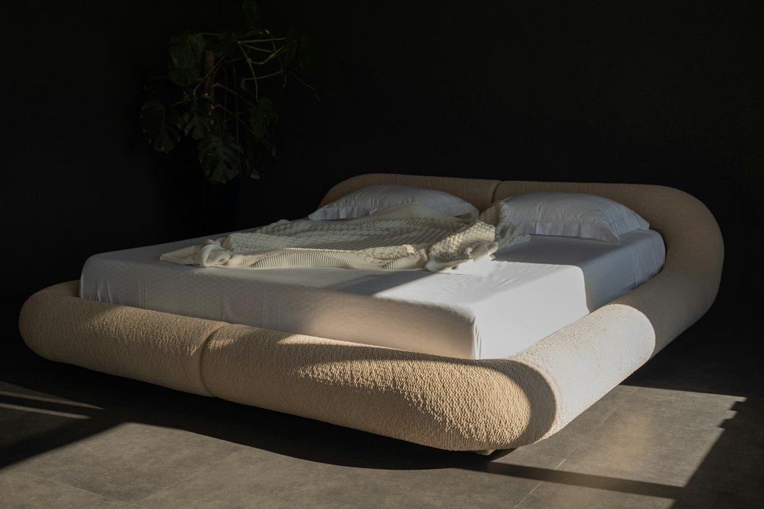 Layered mattress and bedding in a neutral bedroom