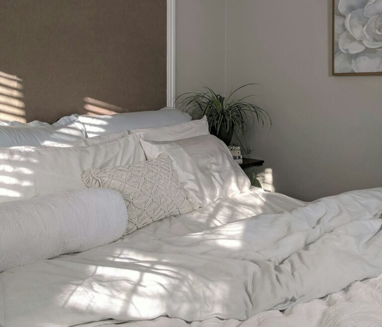 Soft white bedding in a light-filled neutral bedroom