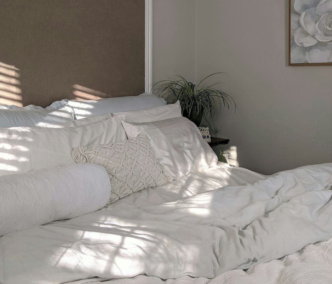 Soft white bedding in a light-filled neutral bedroom