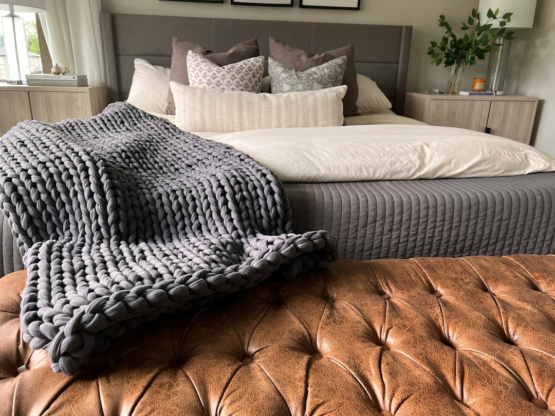 Textured blanket layered across a neutral bed