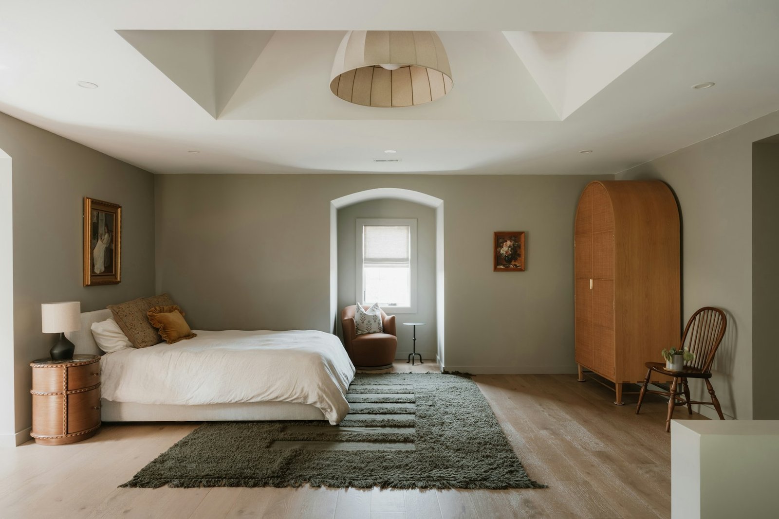 Warm neutral bedroom with a large bed and wood furniture